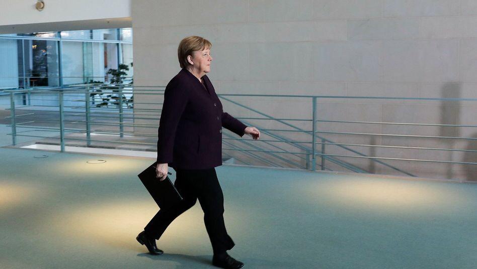 Germany's Merkel returns to office after quarantine stint